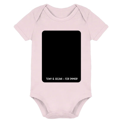 Pale pink baby onesie with black rectangular panel and white text tony & selina für immer aus der statement collection