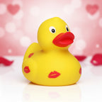Gelbe quietscheente mit roten lippenstiftabdrücken und rotem schnabel perfekt für valentinstag und hochzeit