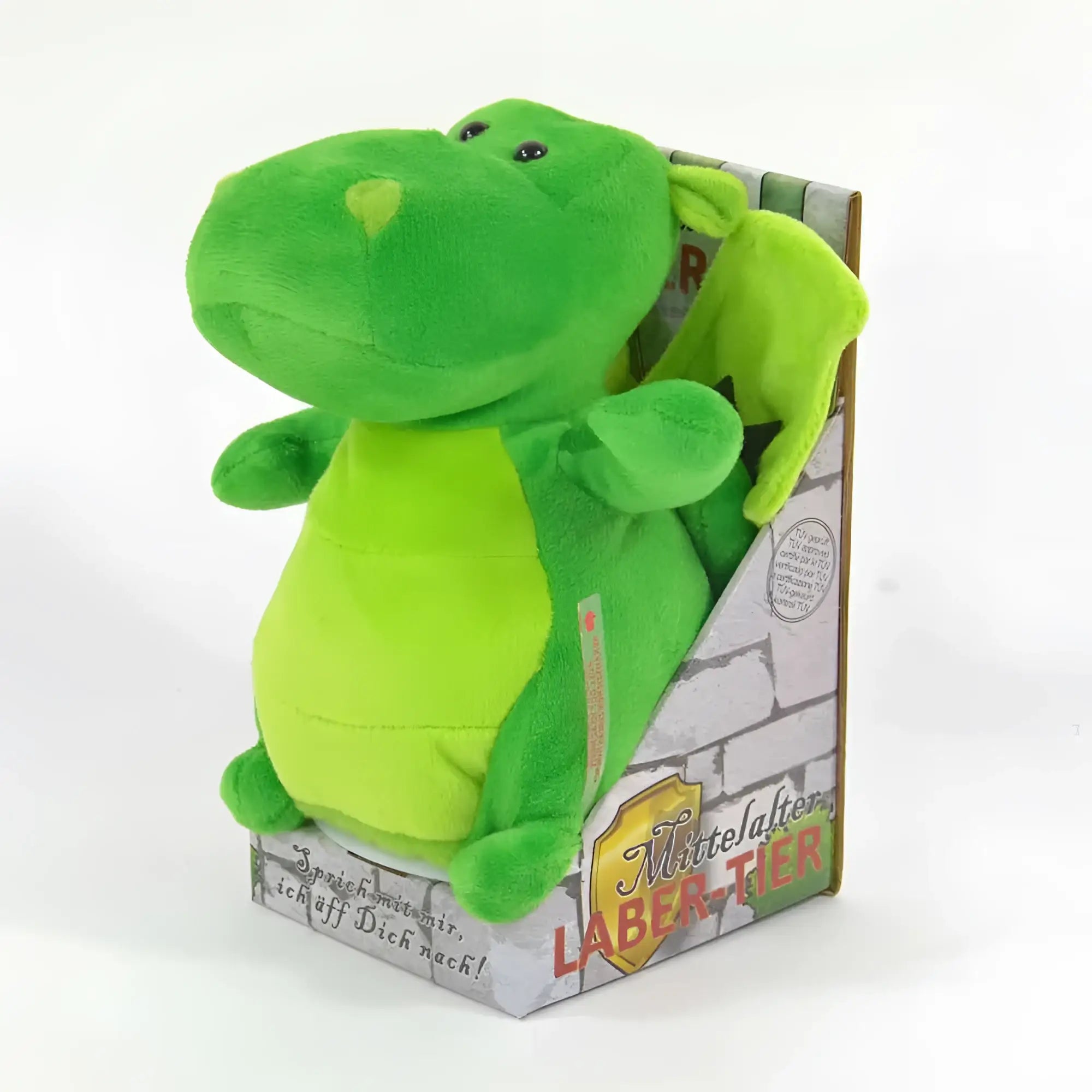 Ein plüsch grüner laber-drache rupert mit hellgrünem bauch und schwarzen knopfaugen in verpackung sitzend
