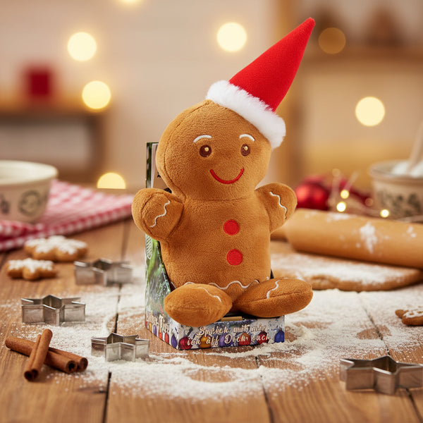 Ein plüschiger gingerbread mann laber-lebkuchenmann ginny mit rotem santa-hut und braunem stoffkörper inklusive batterien