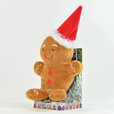 Ein plüsch-laber-lebkuchenmann ginny mit roter santa-mütze und besticktem gesicht sitzt aufrecht in der verpackung