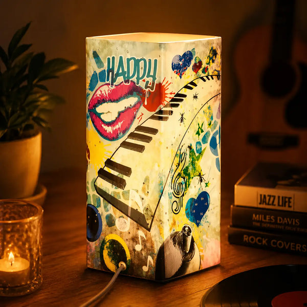 Eine lebendige, rechteckige Tischlampe mit einem farbenfrohen Graffiti-Design und musikalischen Motiven wie Klaviertasten und Lippen.