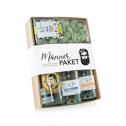 Ein beiger pappe geschenkbox männer-paket mit drei gin tonic flaschen, orangenspritzer und grünem macchiato candy