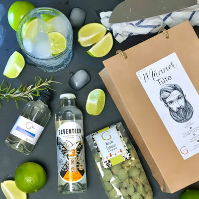 Eine klare glasflasche sieben tonic water mit silbernem deckel und auffälligem etikett im männer tüte präsentkorb