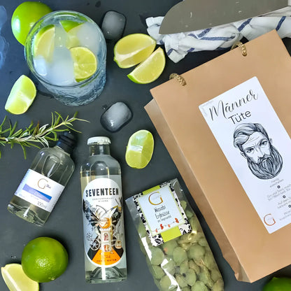 Eine klare glasflasche sieben tonic water mit silbernem deckel und auffälligem etikett im männer tüte präsentkorb