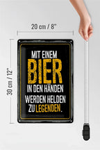 Schwarzes blechschild 20x30cm mit goldumrandung und gelbem text mit spruch über bier und helden