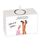 Weißer rechteckiger teelichthalter mit illustration von beinen in schwarzen high heels und pinkem federnboa hält glas