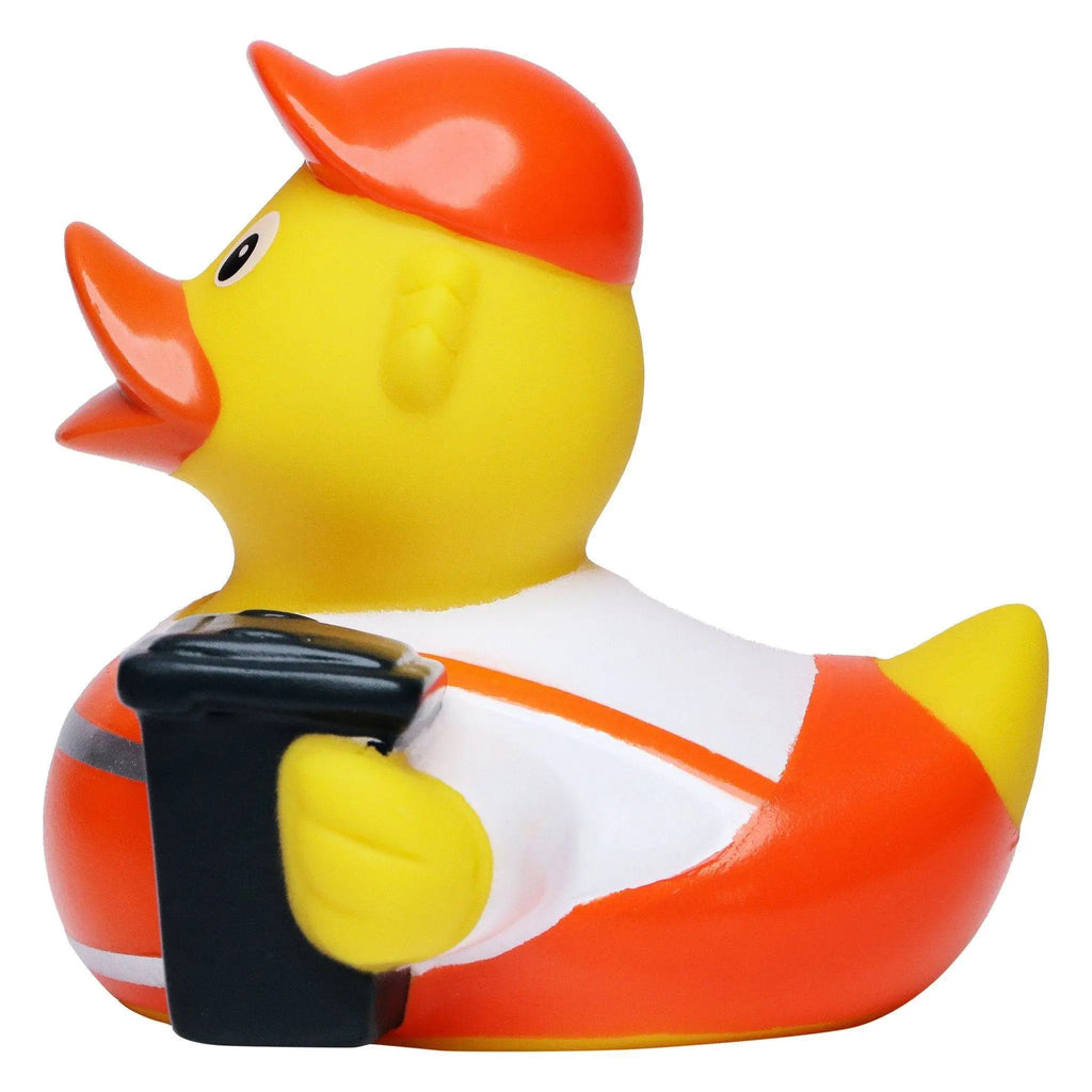 Eine gelbe badeente aus gummi mit orangefarbener mütze und schwarzer kamera als müllmann quietsche-ente