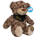 Ein plüschtier bär bodo in braun mit schwarzem oktoberfest bandana und beigen pfoten aus stoff