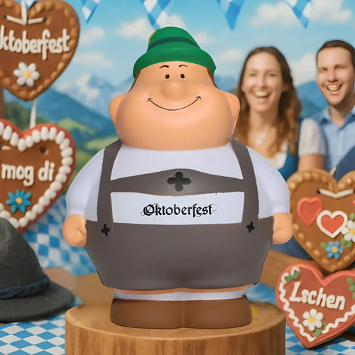 Ein fröhlicher, pummeliger oktoberfest-lookalike mit grünem hut und grauen overalls aus dem oktoberfest geschenkset bert & berta plus 2 lebkuchenherzen