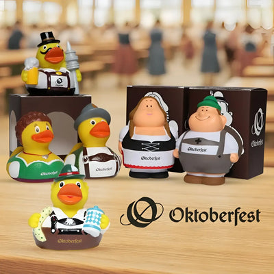 Gelbe gummiente quetschfiguren im oktoberfestkostüm mit lebkuchenherzen im oktoberfest geschenkset bert und berta