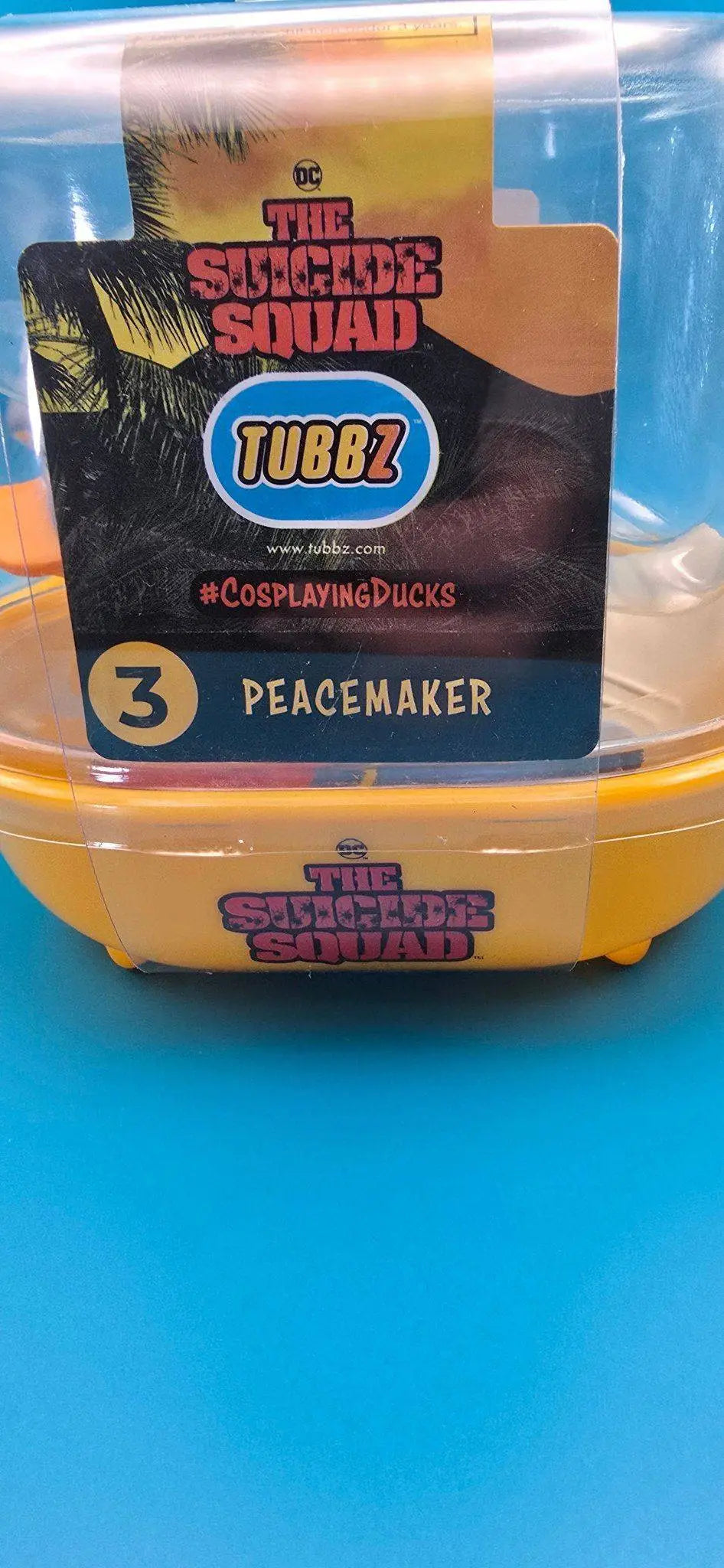 Gelber kunststoffbehälter mit durchsichtigem deckel und schwarzem orangen label für peacemaker tubbz sammlerente pvc offiziell