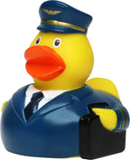Gelbe quietsche-ente als pilot in blauem uniform mit goldbesatz und schwarzer aktentasche zum baden
