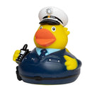 Gelbe quietsche-ente als polizist mit marineblauer uniform und weißer mütze mit emblem badeente