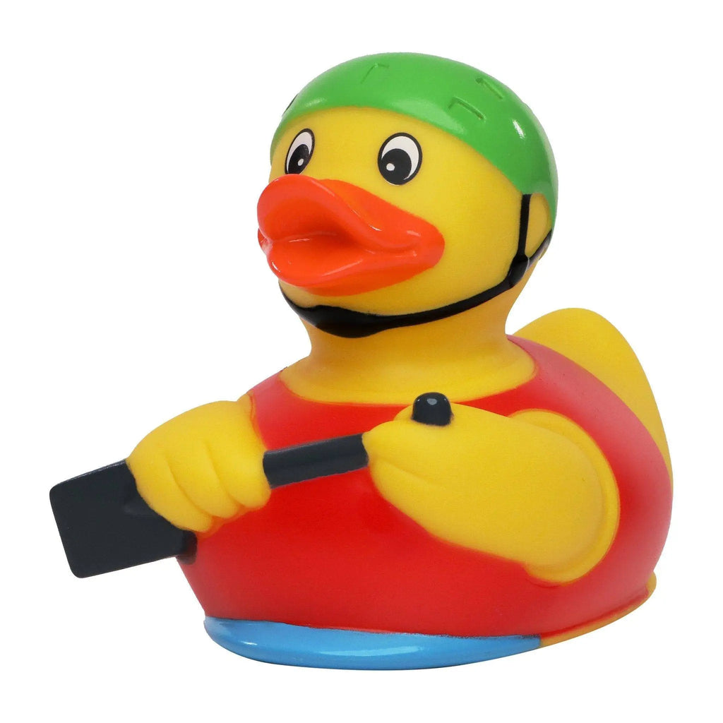 Eine gelbe quietsche-ente mit grünem helm und roter rettungsweste hält ein paddel zum rudern im ruderboot
