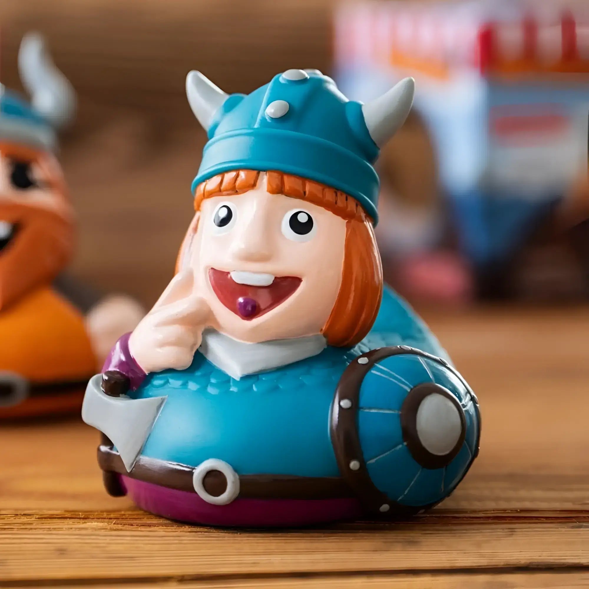 Blaues schnabels badeente wickie mit wikingerhelm und lila akzenten in geschenkverpackung