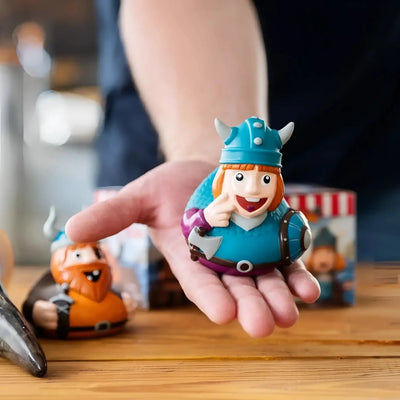 fröhliche blaue und lila schnabels badeente wickie mit wikingerhelm schild und axt in geschenkverpackung
