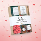 Ein schönes geschenkset präsentkorb mit einer weißen banderole, herzförmigen rosa bonbons und bunten gummy bears
