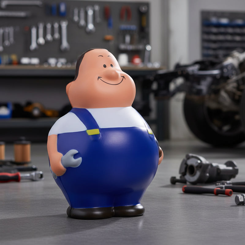 Blaue und weiße cartoonmechanikerfigur schrauber bert mit lächelndem gesicht hält schraubenschlüssel anti-stress-figur