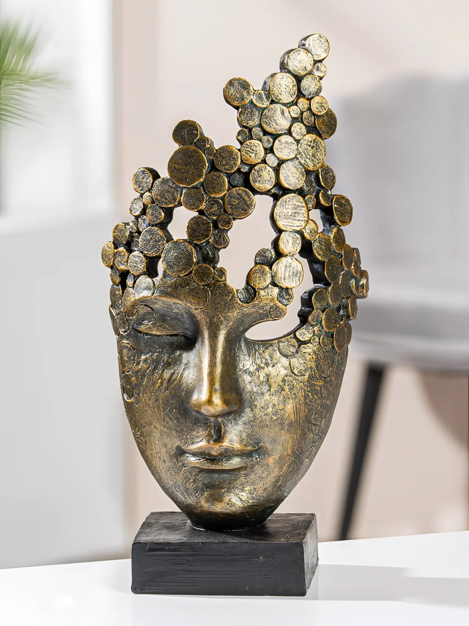 Bronze farbene gesichtsskulptur aus kunstharz mit strukturierter oberfläche und abstrahiertem kronenmotiv von gilde