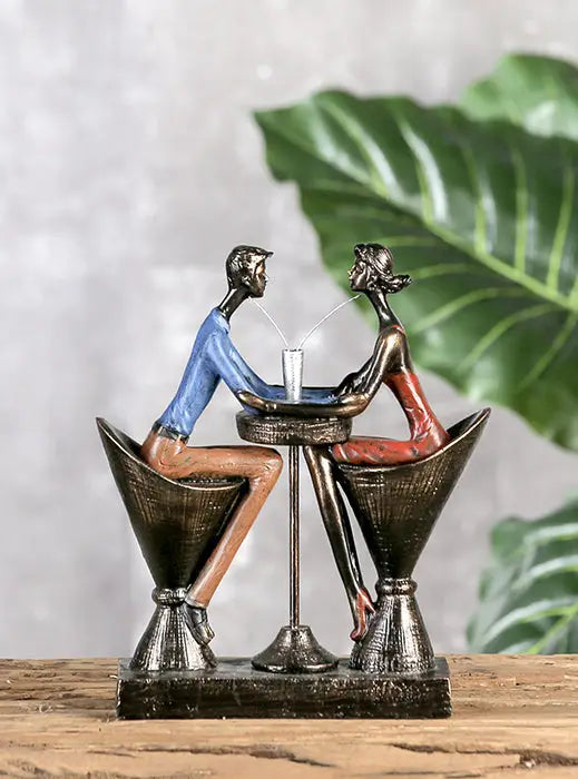 Bronze farbene kunstharz skulptur paar table für two mit sitzenden figuren an mini tisch in martiniglas stühlen