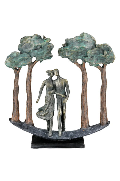 Bronze farbene kunstharz skulptur paar under trees mit vier stilisierten bäumen und grünlichem laub von gilde