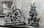 Steampunk silberne affenfigur aus kunstharz mit zylinder und goggles sitzt auf büchern und liest motor-pig von gilde