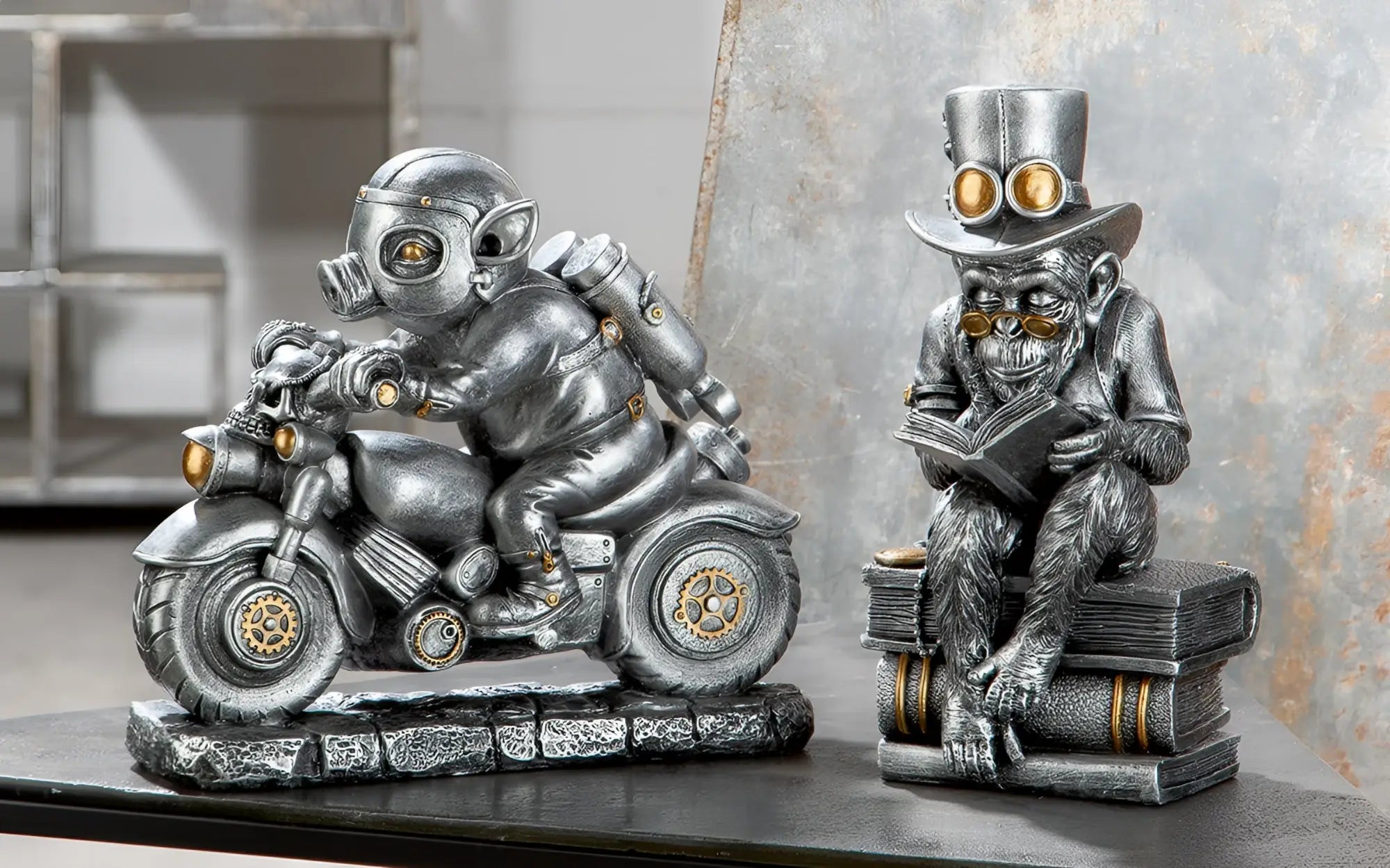 Steampunk silberne affenfigur aus kunstharz mit zylinder und goggles sitzt auf büchern und liest motor-pig von gilde