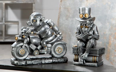 Steampunk silberne affenfigur aus kunstharz mit zylinder und goggles sitzt auf büchern und liest motor-pig von gilde