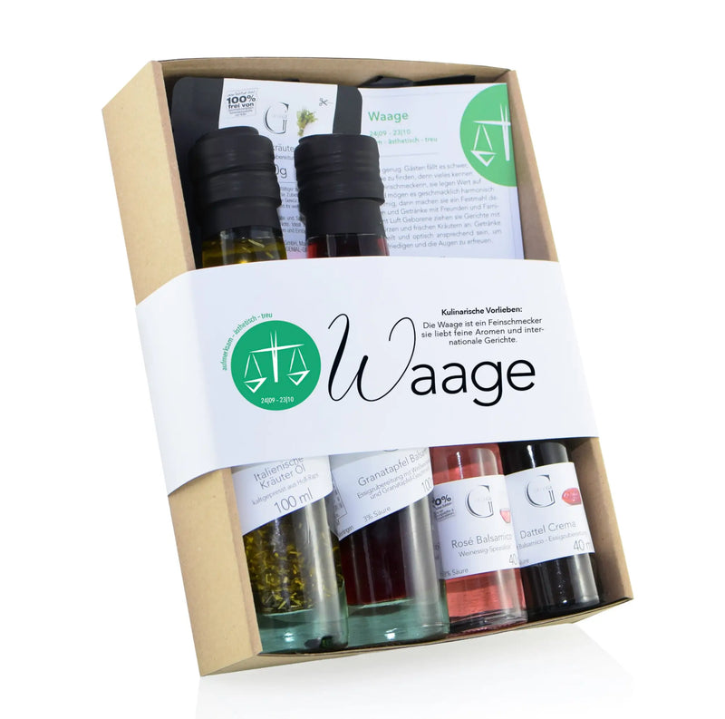 Ein set aus sechs glasflaschen mit schwarzen deckeln gefüllt mit bunten ölen und essigen im sternzeichen waage geschenkbox