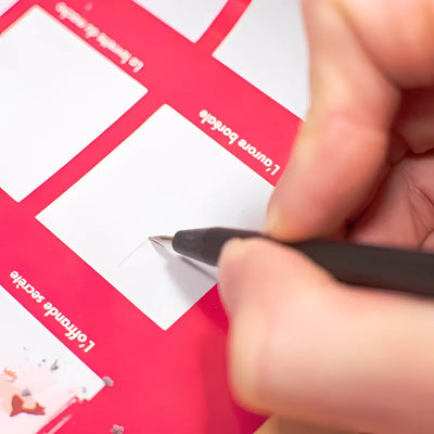 Eine hand hält einen schwarzen stift für kratzposter über eine rotweiße französische rubbelkarte