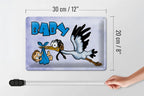 Rechteckiges blechschild 20x30cm mit cartoon-storch in blau und baby-schriftzug auf grauem hintergrund