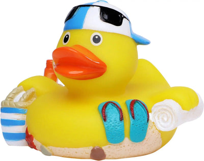 Gelbe quietsche-ente mit blau weiß gestreifter mütze, schwarzer sonnenbrille, strandtasche und türkis flip-flops