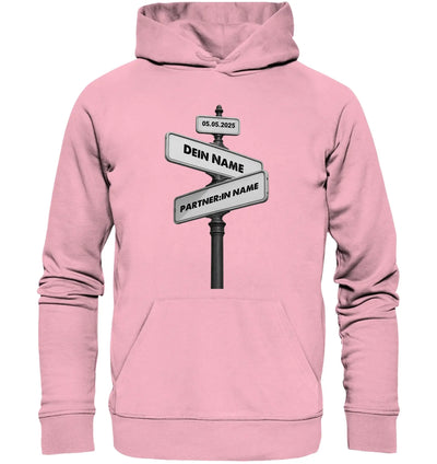 Ein weiches rosa kapuzensweatshirt mit schwarzem und weißem straßenschild und individuellem wunschtext