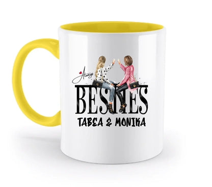 Weiße keramiktasse mit gelbem griff und innen mit illustration zweier frauen und text always besn s tabea & monika
