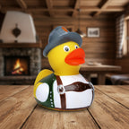Gelbe quietsche-ente mit grauem hut, oranger feder, grünem weste, weißem hemd und braunen hosenträgern in bayerischer tracht