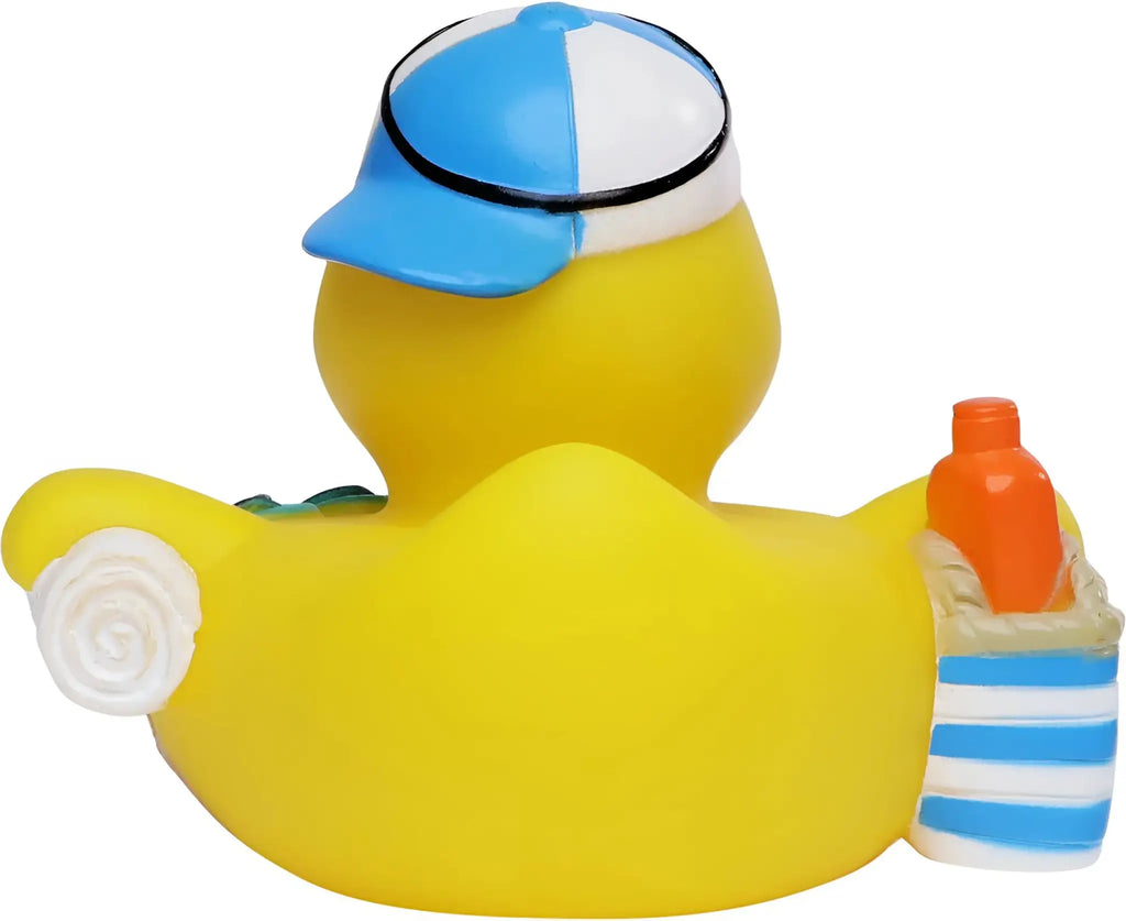 Gelbe badeente mit blau weißer baseballkappe hält eine orange flasche im gestreiften strandtaschen-geschenkseturlaub