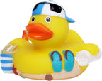 Gelbe badeente im urlaub geschenkset mit blau weiß gestreiftem mütze, schwarzen sonnenbrillen, tasche und flipflops