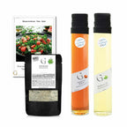 Zwei schlanke glasflaschen mit schwarzem verschluss eine mit bernsteinfarbenem haselnussbalsam und die andere mit blassem basilikumöl im wassermelonen feta salat-set geschenkkorb