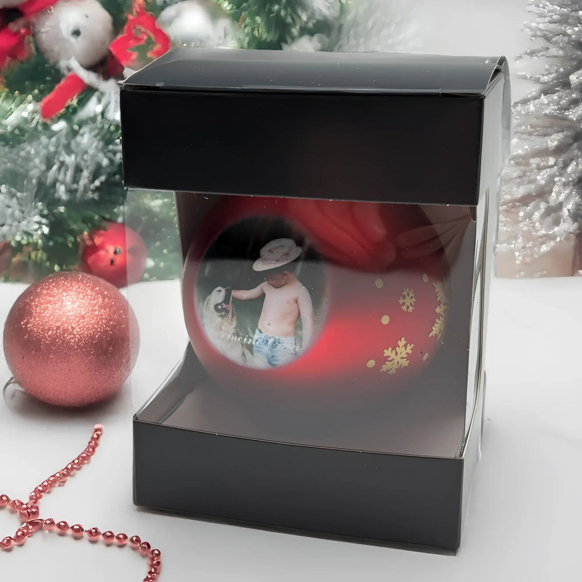 Rote weihnachtskugel mit goldenen schneeflocken und rundem foto eines kinders mit hund, personalisierbar und in drei farben erhältlich