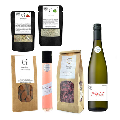 Grüne glasflasche mit merlot rotwein und schwarzer folie im weinabend geschenkset präsentkorb