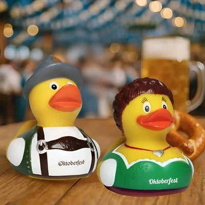 Ein gelbes gummienten-duo von schnabels mit tracht und dirndl für oktoberfest spaß im badeenten-set