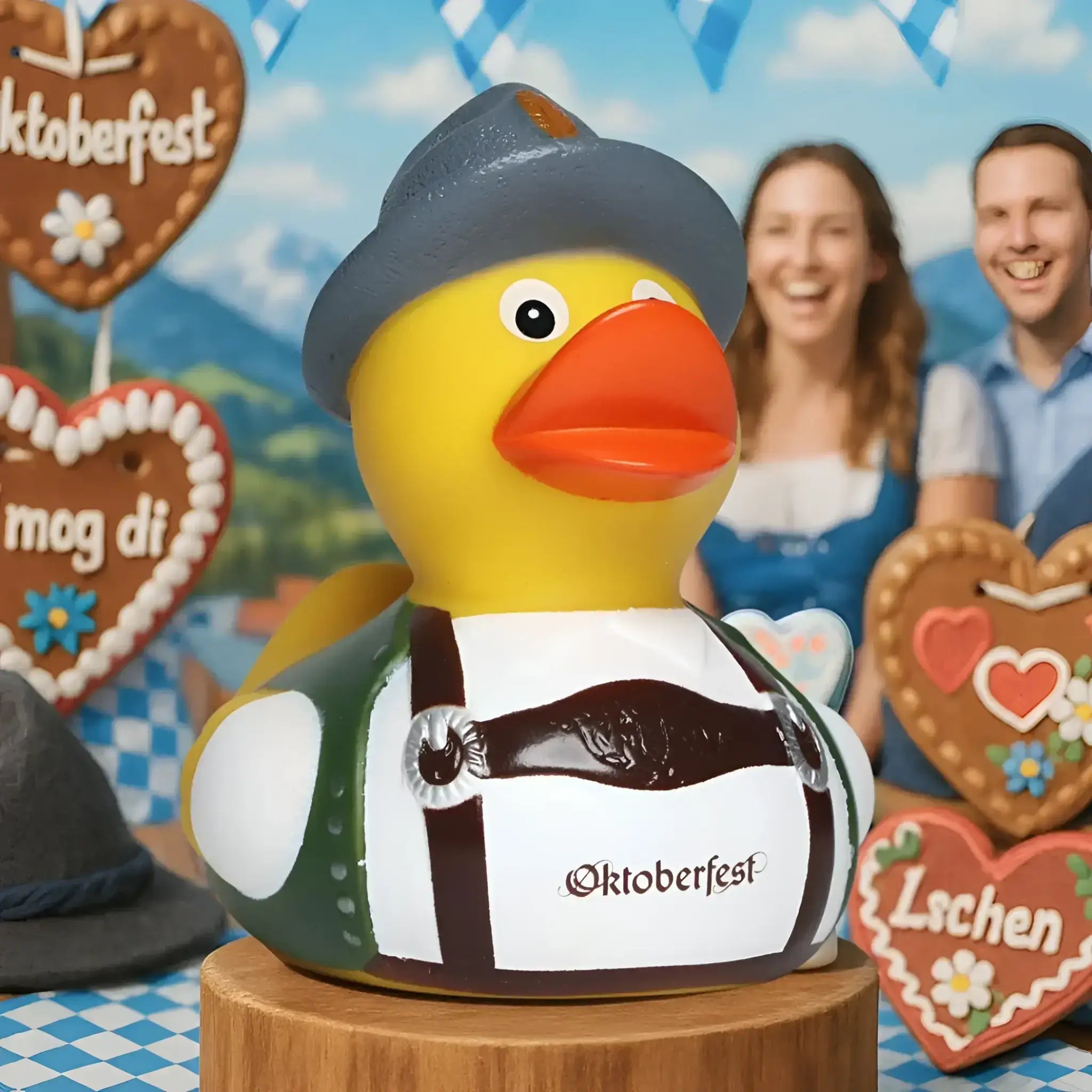 Gelbe gummiente mit grauem hut grün weißem outfit und braunen hosenträgern mit oktoberfest logo von schnabels