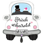 Weißer riesen luftballon in form eines hochzeitsautos mit schwarzen und rosa akzenten und einem paar in formeller kleidung drin