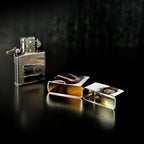 Silberner zippo feuerzeug mit reflektierendem metallfinish und graviertem branding neben offenem etui mit fotos