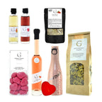 Pink roséweinflasche mit weißem etiket und silberner folie im zur hochzeit geschenkset präsentkorb
